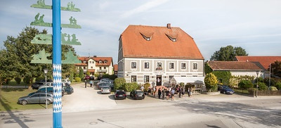 Außenansicht mit Parkplatz und Maibaum Gasthof zur Post