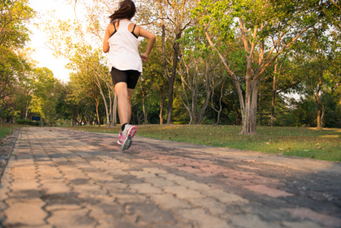 Young woman running in wood, training and exercising for trail run marathon endurance in morning sunrise. Fitness healthy lifestyle concept. Vintage effect style pictures.
