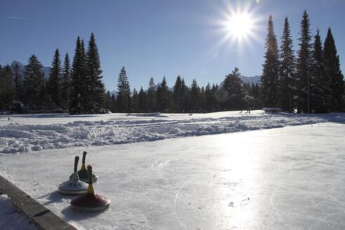 Natur-Eisplatz in Wallgau im Winter mit Sonnenschein
