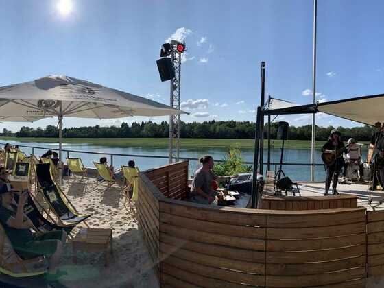 Sitzbereich des Munich Beach Resorts mit Ausblick auf Regattastrecke