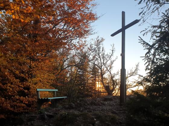Gipfelkreuz der Hohen Dirn in der Abendsonne im Herbst.