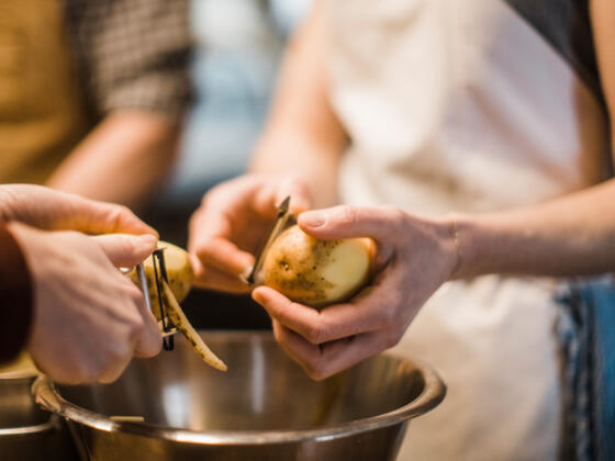 zwei Personen schälen Kartoffeln - Symbolbild