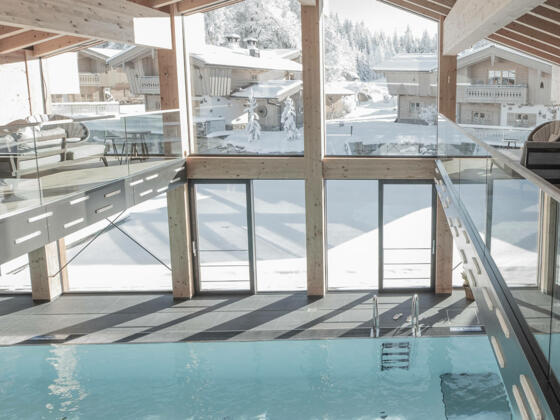 INNs HOLZ Natur- &amp; Vitalhotel**** | Indoorpool im Winter mit Blick auf Chaletdorf