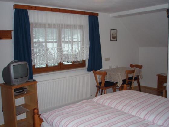 Doppelbett mit Fernseher und kleine Sitzecke