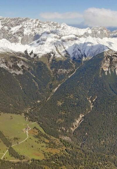 Panorama kompletter Wettersteinkamm von Süden: Im Vordergrund das Gaistal und rechts Leutasch; Hinten links: schneebedecktes Zugspitzplatt mit der Zugspitze  etwa mittig dahinter und dem Einschnitt des Gatterls davor; im linken Bilddrittel Hochwanner