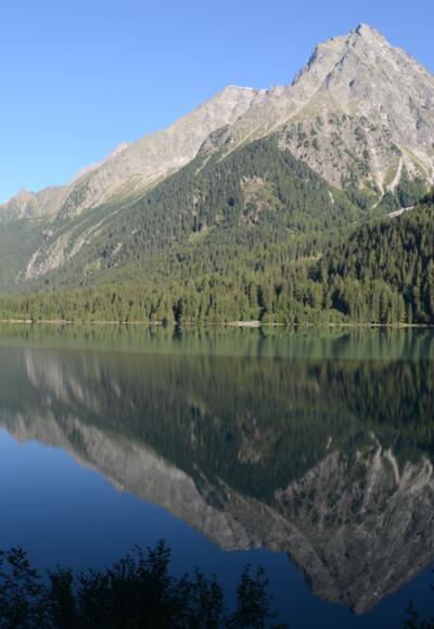 Die Runde schließt sich und vom Ufer des Antholzer Sees schaut man noch einmal hinauf zu Wild- und Hochgall.