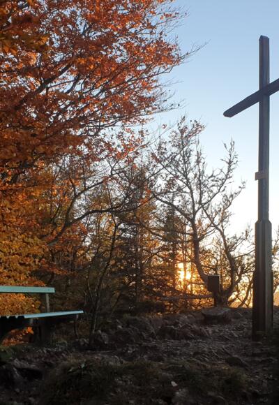 Gipfelkreuz der Hohen Dirn in der Abendsonne im Herbst.