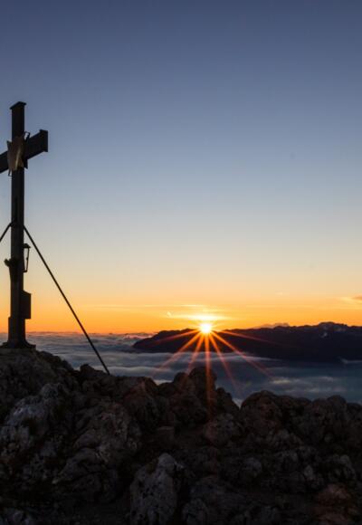 Die Sonne spitzt über dem Untersberg hervor.