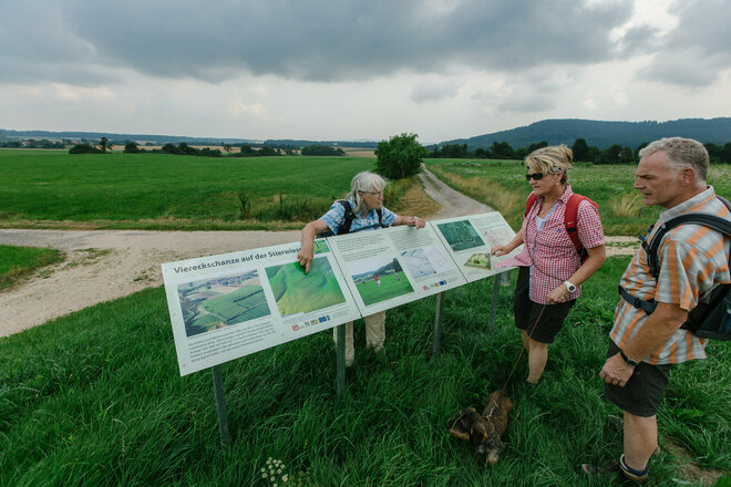 Wanderer kucken sich die Infotafeln genau an.