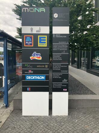 Tafel mit Läden MONA Nahversorgungszentrum