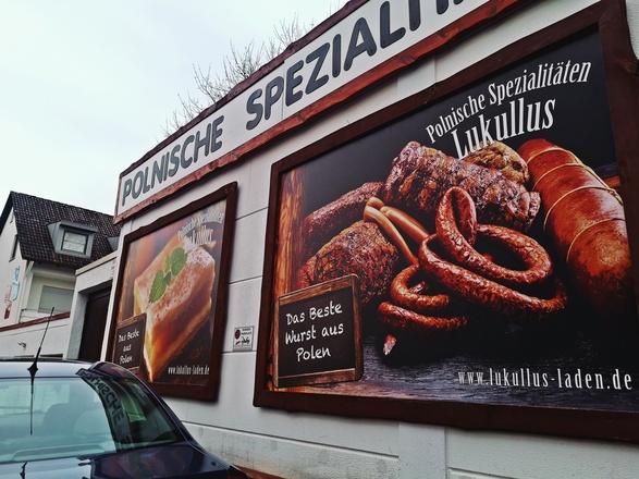 Plakate auf der Fassade des Lukullus Supermarkts