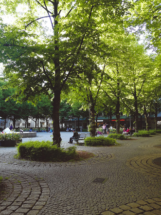 Menschen auf Parkbänken am Hohenzollernplatz