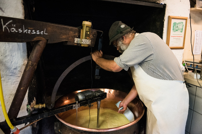 Alpsenn Bene bei der Käseherstellung