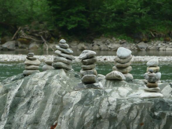 Kleine Kunstwerke in Form von Steinmännchen an der Iller bei Fischen im Allgäu
