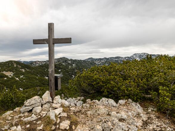 Gipfelkreuz auf dem Hirschangerkopf mit dem Untersbergplateau im Hintergrund.