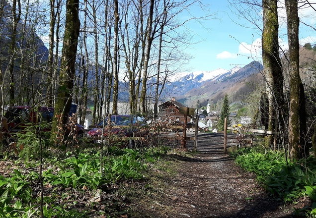 Blick auf den Parkplatz, dahinter der Ortsrand von Schnepfau.