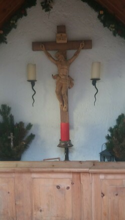 Das Altarkreuz, geschmückt von zwei Kerzenleuchtern.