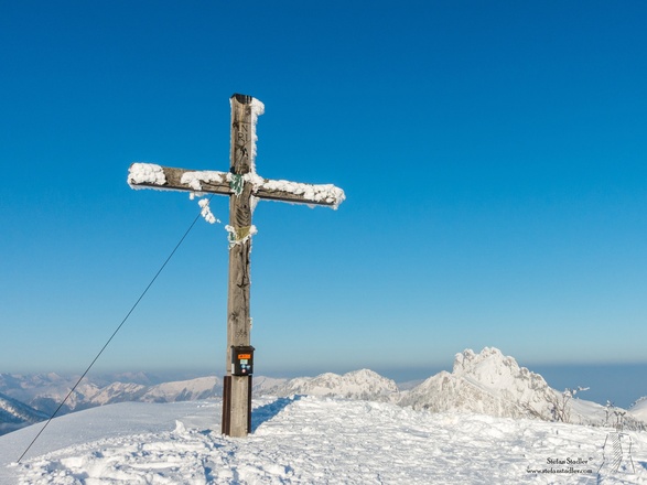 Gipfelkreuz auf der Hochplatte mit Kampenwand im Background.