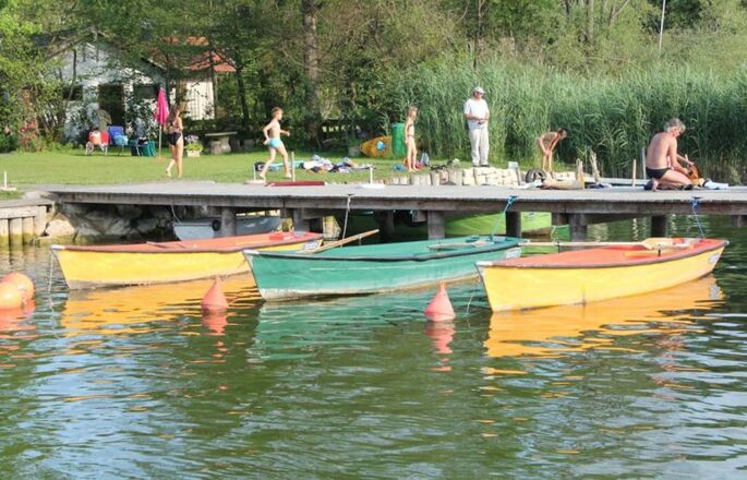 Steg mit Personen und Booten.