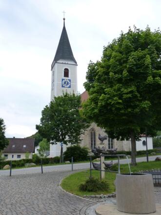 Kirche und Dorfbrunnen am Rathausplatz