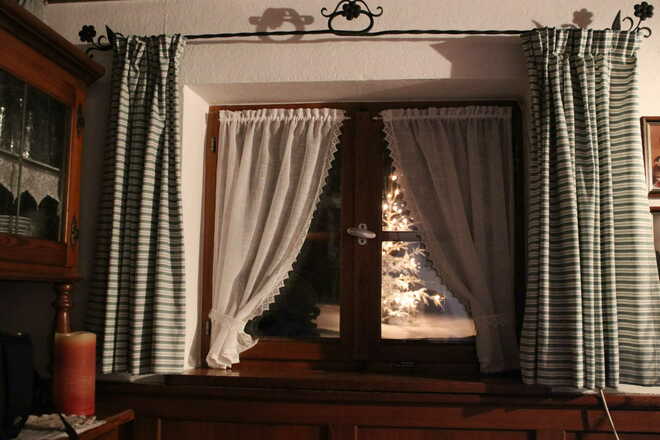 Weihnachtszeit mit Christbaum vorm Fenster