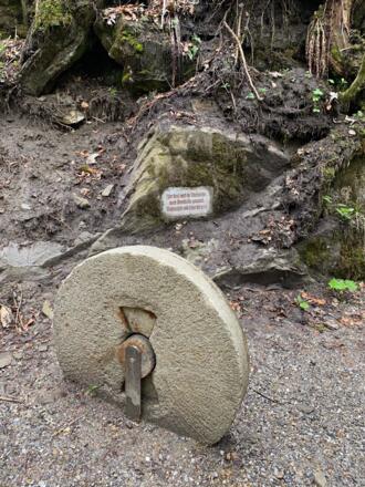 Alter Mühlstein und Gedenktafel an die Tobelmühle am Speckbacher WasserfallW
