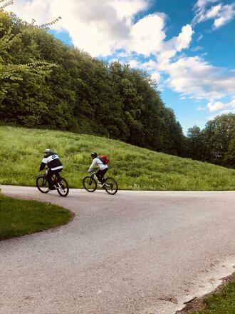 Mountainbiker auf dem Weg hoch zum Windrad am Fröttmaninger Berg