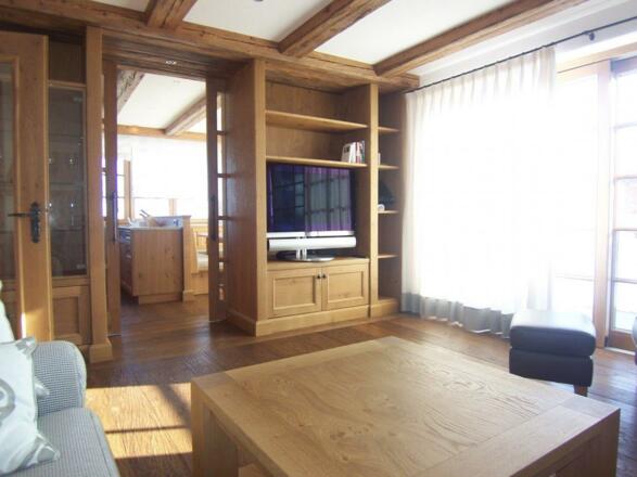 Wohnzimmer mit TV und Blick in Küche