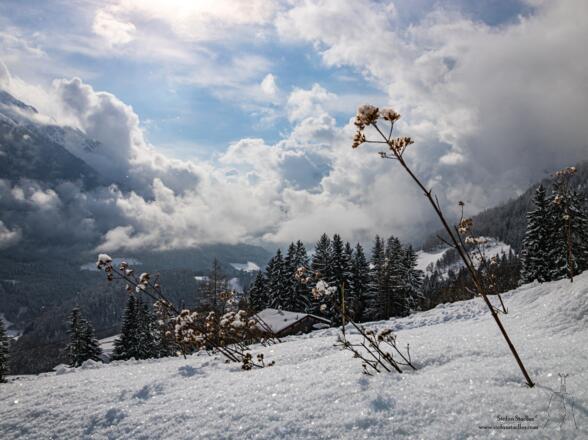 Der Schnee glitzert unter wilder Wolkenstimmung.