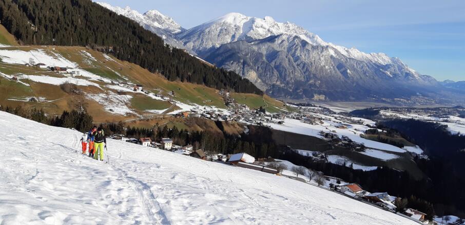 ... links (südlich) haltend Richtung Waldrand. (Blick auf Oberperfuss, hinten in der Mitte der Große und Kleine Solstein im Karwendel.)