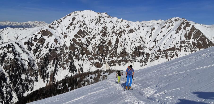 Aufstieg über die Nordhänge, bevor man wieder auf den Grat quert. Unten das Padastertal, hinten der Bentlstein (2436 m).
