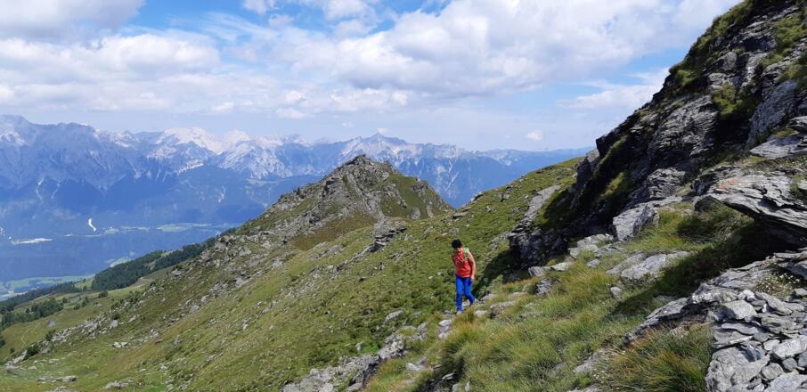 Kurz führt der Weg wieder auf der Westflanke entlang. Hinten die Wattenspitze, dahinter der Hochnissl im Karwendel-Hauptkamm.
