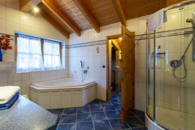 Bad mit Dusche, Whirlwanne und Zugang zur Sauna