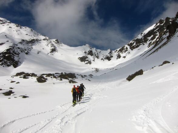 Aufstieg durch das Steintal. Ganz hinten im Talgrund der Steintalsattel, links davon der flache Sattel und der abfallende Steilhang über den der Aufstieg erfolgt. Der kleine, unscheinbare Felsspitz links des Schneesattels ist der nördliche Gipfel der