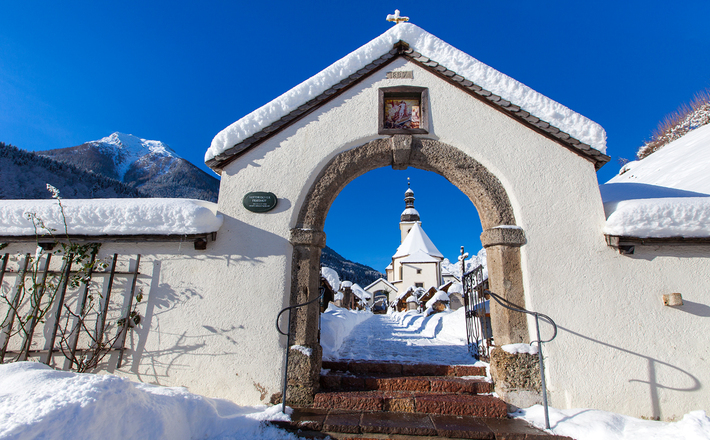 Blick durch das Friedhofstor auf die Kirche St. Sebastian