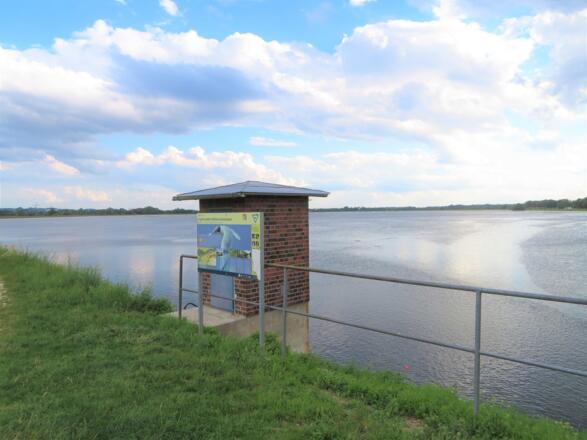 Blick auf Speichersee und Hinweisschild Vogelfreistätte Mittlere Isarstauseen