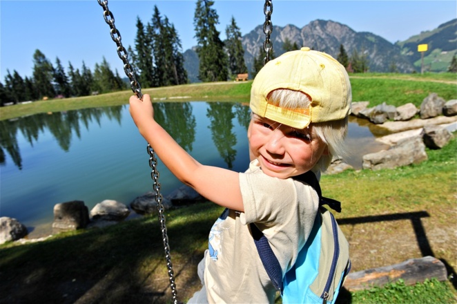 Kind auf Schaukel beim Speicherteich Teichwanderweg Alpbach