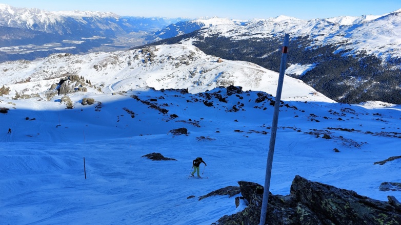 Lange Holzstangen markieren den Aufstieg und erleichtern die Orientierung bei schlechten Sichtverhältnissen. Unten der Schartenkogel (2311 m).