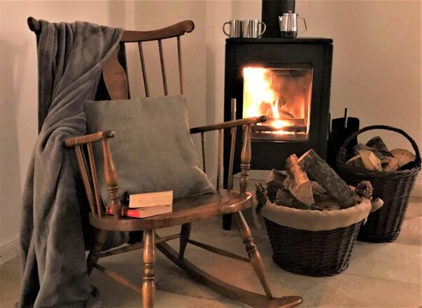 Im Schaukelstuhl hört man das knisternde Feuer im Kamin der Fewo zwischen Berg und Bach in Kiefersfelden