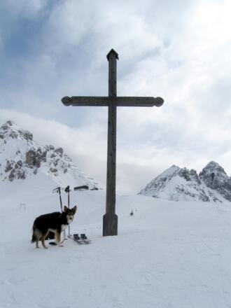 Das einfache Gipfelkreuz am Birgitzköpfl - Im Hintergrund Ampferstein und Marcheisenspitze rechts und ein Teil des Felsaufbaus der Nochspitze links. Der Einschnitt in der Mitte ist das sog. &quot;Halsl&quot;. Und genau in der Mitte hinter dem Gipfelkreuz blitz