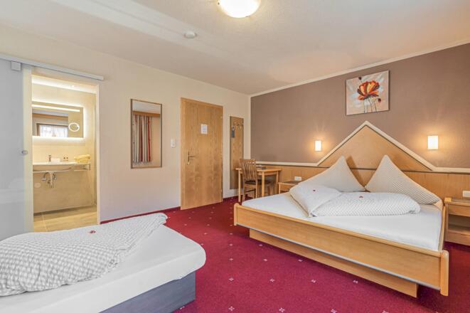 Dreibettzimmer mit Blick ins Badezimmer