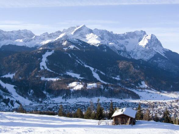 Hinter der Eckenhütte erhebt sich das Wettersteingebirge mit Alpspitze und Zugspitze.