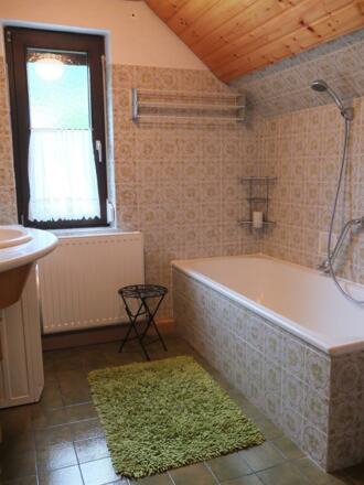 Badezimmer mit Wanne, Toilette, Waschmaschine