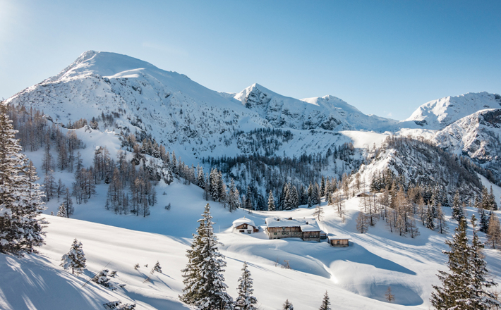 Winterliches Schneibsteinhaus mit dem namensgebenden Gipfel im Hintergrund