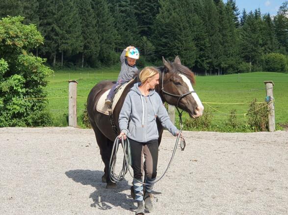 Kind am Pferd mit Reitbegleiterin