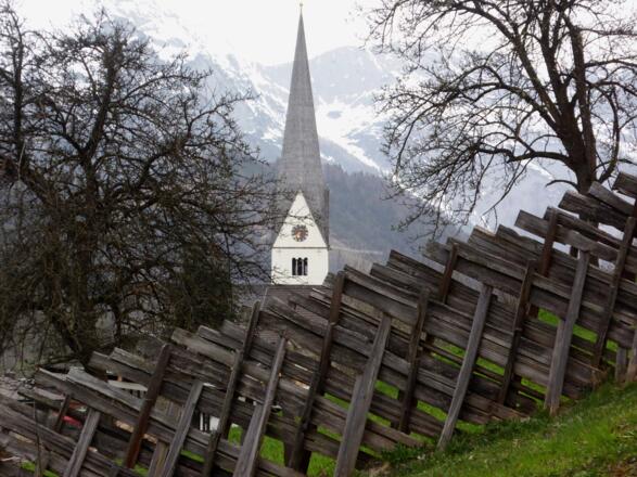 Ein typischer Pongauer Girschtenzaun vor dem gotischen Kirchturm in Pfarrwerfen.