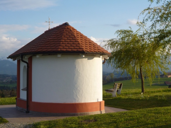 Die kleine Kapelle am östlichen Ortsrand von Schönberg steht direkt vor der eindrucksvollen Kulisse der Alpenkette.