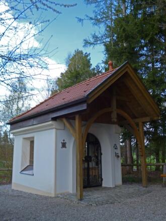 Die Marienkapelle am Wolfbichl liegt gut versteckt hinter Bäumen.