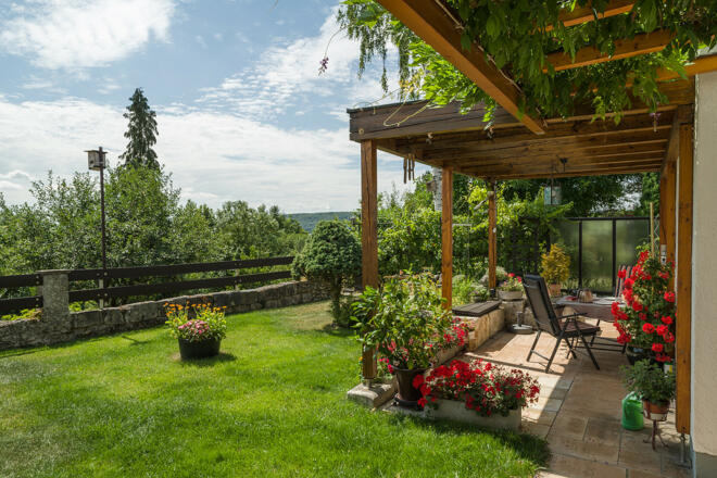 Blick über Garten und Terrasse ins Tal
