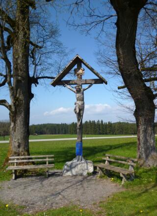 Großes Wegkreuz mit Bänken wenig nördlich der Wieskirche.